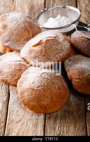 Bunuelos mexikanischen Krapfen bestreut mit Puderzucker close-up auf dem Tisch. Vertikale Stockfoto