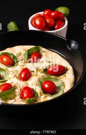 Essen Konzept steigende Teig für Hausgemachte organische Focaccia in Skillet eiserne Pfanne auf schwarzen Hintergrund mit Kopie Raum Stockfoto