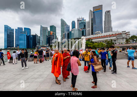 Touristen posieren für Fotos Vor dem Merlion Statue und die Skyline von Singapur, Singapur, Südostasien Stockfoto