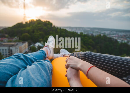 Paar Festlegung und genießen Blick auf den Sonnenuntergang über der Stadt Stockfoto