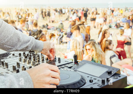 Nahaufnahme von Hand spielen Musik von DJ Plattenspieler an Beach party Festival - Masse Menschen tanzen und Spaß im Club outdoor Stockfoto