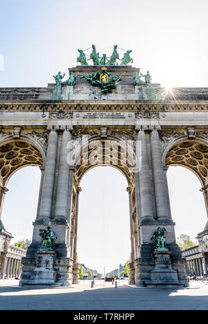 Low Angle View des Arcade du Cinquantenaire, der Triumphbogen im Cinquantenaire-Park in Brüssel, Belgien, gegen das Sonnenlicht. Stockfoto