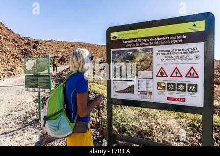 Frau walker Lesen der Informationen Zeichen am Anfang der Spaziergang über Montaña Blanca, Las Cañadas del Teide auf den Pico del Teide, Teneriffa, Canar Stockfoto