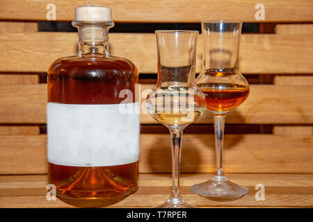 Eine volle Flasche Whiskey mit zwei Gläsern und Text Raum Zeichen auf der Flasche Stockfoto