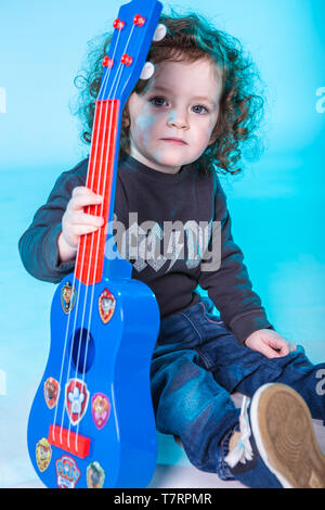 Kleinkind Mädchen lernen Gitarre zu spielen. Stockfoto