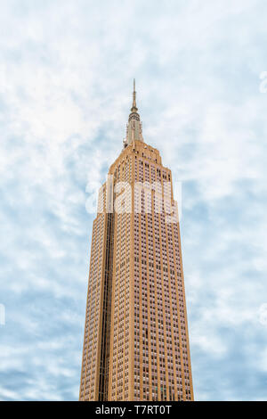 New York City, USA - 7. April 2018: die Spitze des Empire State Building gegen bewölkt Blauer Himmel bei Tag auf dem Dach berühmten ikonischen Gebäude in NEW YORK CITY isoliert Ihre Stockfoto