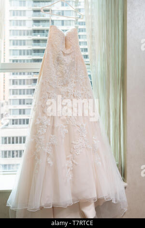 Lange Hochzeit Kleid hängen Aufhänger von Fenster Fensterbänke in städtischen moderne New York City NY NEW YORK CITY apartment hotel Hohes Condo-Gebäude Stockfoto