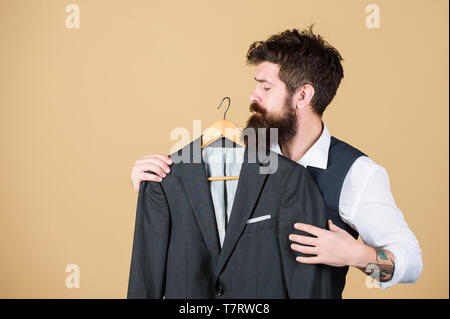 Wenn der Laden so formell. Bärtiger Mann auf formale Abnutzung Boutique. Hipster Auswahl Anzug Jacke im Kleiderschrank. Klassische Formalen Blick von fashion model. Stockfoto