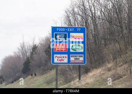 Harrisburg, USA, 6. April 2018: Die ländlichen Pennsylvania Landschaft im Frühling mit blau Ausfahrt auf der Autobahn für Lebensmittel mit Dunkin Donuts, Mcdonalds Stockfoto