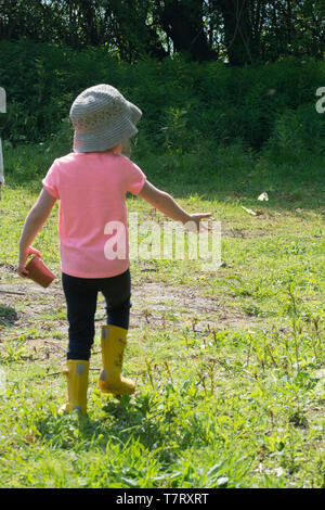 Vier Jahre altes Mädchen auf dem Land genießen Sie einen Schmetterling. Kinder und Natur Konzept. Stockfoto