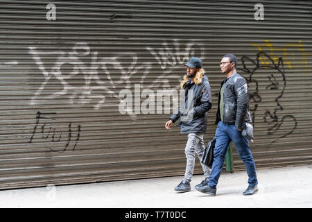 New York City - 6. April 2018: beschäftigte Leute Männer gehen auf Gehweg Pflaster durch geschlossene Garage in New York Midtown Stockfoto