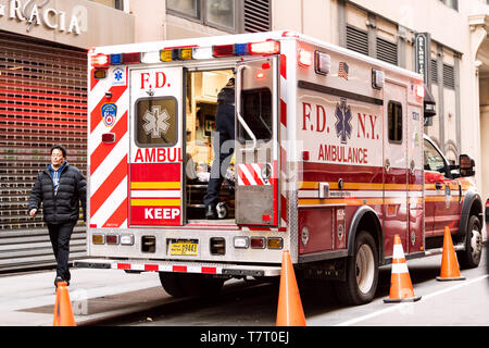 New York City - 6. April 2018: NEW YORK CITY Midtown mit FDNY rot Krankenwagen offenen Lkw mit Person auf Keilrahmen auf der Straße geparkt Stockfoto