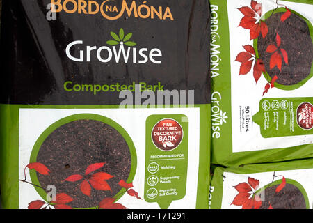 Ein Stapel von Taschen von Rindenhumus zur Unterdrückung von Unkräutern und Verbesserung der Bodenqualität für den Verkauf in einem Gartencenter Stockfoto