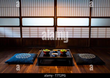 Traditionelle japanische machiya Haus oder Ryokan Restaurant mit Schwarz lackiertem Holz Tisch und Edamame Sojabohnen Essen mit natto und Sojasauce Stockfoto