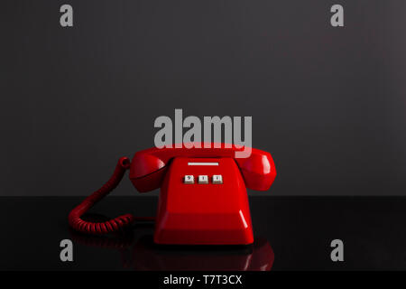 Notruf 911 auf dem Telefon, Red Old vintage Telefon auf schwarzem Hintergrund und Schreibtisch, Notruf Konzept. Stockfoto