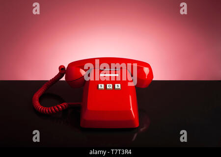 Notruf 911 auf dem Telefon, Red Old vintage Telefon auf schwarzem Hintergrund und Schreibtisch, Notruf Konzept. Stockfoto