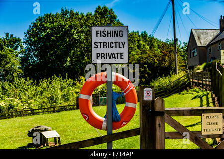 Streng Angeln Private keine Fischerei Schild mit einem Lebensrettenden Boje, durch den Fluss bis in Heatherslaw, Northumberland, Großbritannien. Juni 2018. Stockfoto