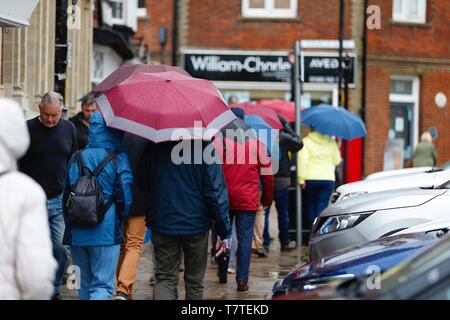 Tenterden, Kent, Großbritannien. 09. Mai 2019. UK Wetter: regnerisch das Wetter in Tenterden, Kent, die voraussichtlich den ganzen Tag andauern, Clearing später an diesem Abend. Max. Temperaturen von 12 Grad C zu erwarten sind. Eine Gruppe von Menschen, die Sonnenschirme schirmt sich vor dem Regen. © Paul Lawrenson 2019, Foto: Paul Lawrenson/Alamy leben Nachrichten Stockfoto