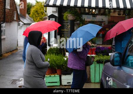 Tenterden, Kent, Großbritannien. 09. Mai 2019. UK Wetter: regnerisch das Wetter in Tenterden, Kent, die voraussichtlich den ganzen Tag andauern, Clearing später an diesem Abend. Max. Temperaturen von 12 Grad C zu erwarten sind. Eine Gruppe von Menschen, die Sonnenschirme schirmt sich vor dem Regen. © Paul Lawrenson 2019, Foto: Paul Lawrenson/Alamy leben Nachrichten Stockfoto