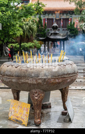 Hong Kong, China - 7. März 2019: Insel Lantau. Buddhistische Kloster Po Lin. Große braune Stein, Metall Gefäß, worin Räucherstäbchen brennen vor o Stockfoto