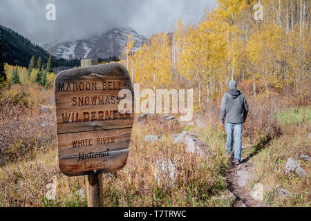 Eine hölzerne Maroon Bells Snowmass Wilderness Trail mit ein Wanderer im Herbst in die Colorado Rockies, Aspen, Colorado, USA Stockfoto