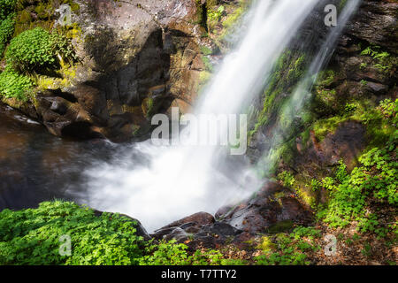 Blick von oberhalb des malerischen Wald Wasserfall Krmolj auf alten Berg, sonnenbeschienenen Felsen und Pflanzen lebhaftes Grün im Frühjahr, Streaming der Klippe Stockfoto