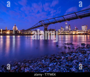 Ein Blick auf den herrlichen St. Pauls Kathedrale und die Millennium Bridge über die Themse in London. Die modernen Wolkenkratzer in der Ci Stockfoto