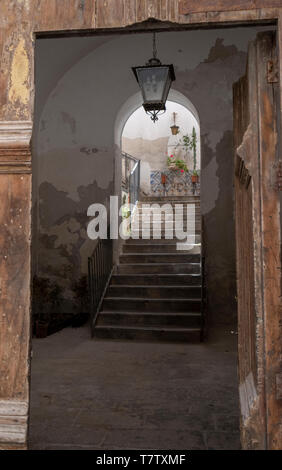 Holz- Tor zu einer steinernen Treppe in der Altstadt von Cefalu, Sizilien. Stockfoto