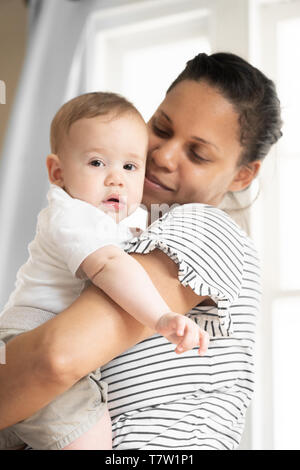 Mutter hält Ihr Baby (6 Monate alt) in Ihrem Haus in nördlichen Philadelphia Stockfoto