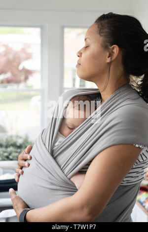 Mutter hält Ihr Baby (6 Monate alt) in Ihrem Haus in nördlichen Philadelphia Stockfoto