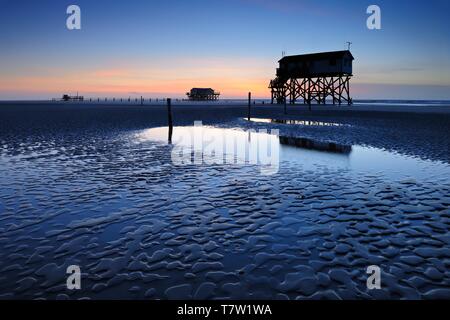 See Häuser bei Ebbe am Strand bei Sonnenuntergang, St. Peter-Ording, Nationalpark Schleswig-Holsteinisches Wattenmeer, Schleswig-Holstein, Deutschland Stockfoto