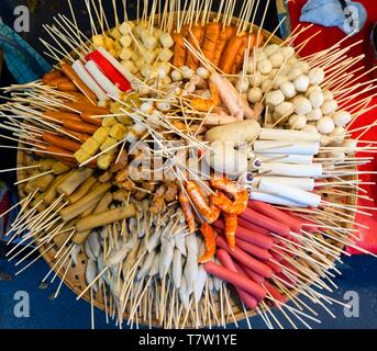 Verschiedene Spieße mit Wurst und Fleisch, Frikadellen, in Bambus Korb auf einem Markt, thailändische Küche, Thailand Stockfoto