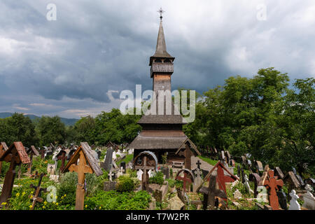 Ieud Hill Kirche und ihren Friedhof, der ältesten hölzernen Kirche im Banat, Rumänien unter dramatischen Himmel. Die Kirche gehört zu einer Sammlung von Holz- Chur Stockfoto