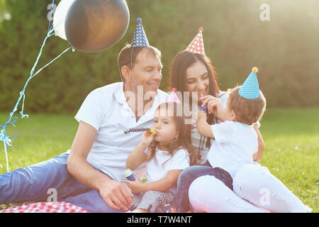 Eltern wollen Kinder zum Geburtstag im Park. Stockfoto