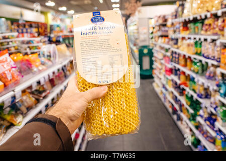 Paris, Frankreich, 27.Dezember, 2017: der Mensch hand POV persönliche Perspektive holding Fusili lunghi bucati din Napoli Teigwaren in modernen Supermarkt mit mehreren Produkt in den Regalen Stockfoto