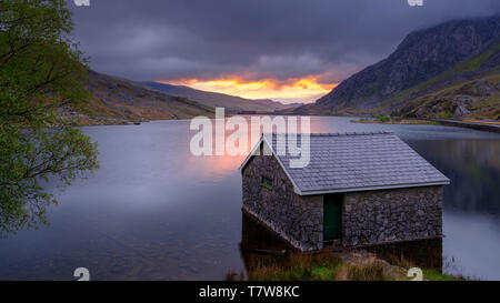 Llyn Ogwen, Großbritannien - 3. Mai 2019: Sonnenaufgang über Llyn Ogwen und Bootshaus, Snowdonia National Park, Wales, UK. Stockfoto