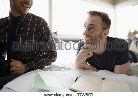 Männliche homosexuelle Paare von zu Hause aus arbeiten, sprechen an Bed