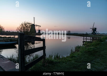 Twight licht sonnenaufgang auf der Unesco-mühle Silhouette in der Mitte des Kanals, Alblasserdam, Niederlande Stockfoto