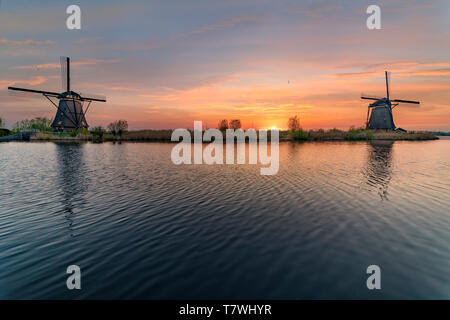 Lange Exposition der Kinderdjik Mühle sunrise Reflexion auf dem ruhigen Wasser des Alblasserdam canal Stockfoto