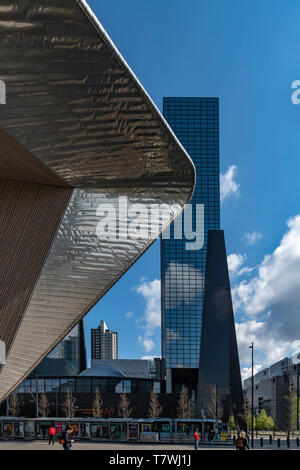 ROTTERDAM, 13. April 2019 - Rotterdam Bahnhof Struktur, die auf die modernen Gebäude und eine Straßenbahn warten auf Reisende unter einem sonnigen Tag leuchtet Stockfoto