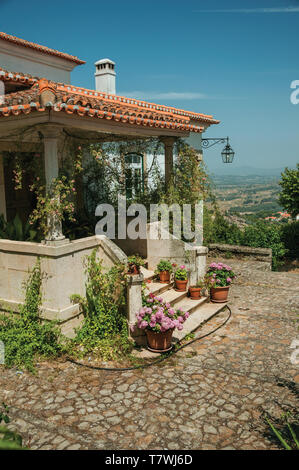 Altes haus Fassade mit Treppe zur Terrasse voller Blumen, auf hügeligen Landschaft bei Monsanto. Eine nette und besondere historische Dorf von Portugal. Stockfoto