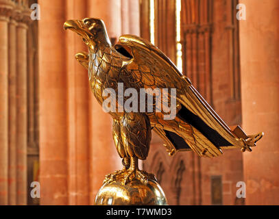 Klassische Rednerpult mit glänzendem Messing poliert Adler auf einem Globus vor Sandstein Spalten in der Kathedrale von Carlisle, Cumbria, England gehockt Stockfoto