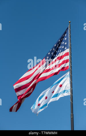 Die kommunalen Flagge von Chicago und die amerikanische Flagge im Wind weht in Chicago gegen blauen Himmel Stockfoto