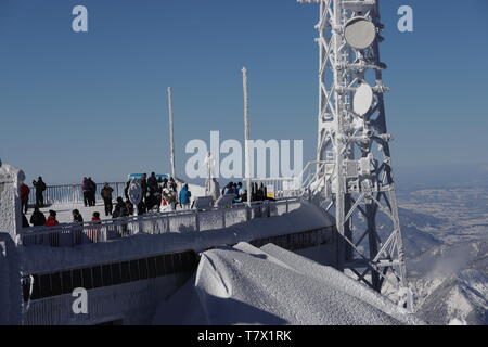 Zugspitze: Blick auf die winterliche österreichische Plattform mit Besuchen und der vereisten Hölzernen Statue 'Himmelsstürmer'. Stockfoto