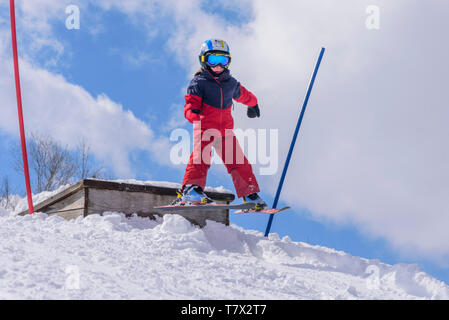 Mutige Junge springen Mutige von einer hölzernen Rampe Stockfoto