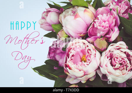 Happy Mother's Day text Karte mit Blumenstrauß aus rosa Pfingstrose Blüten. Pastell-blaue Hintergrund. Stockfoto