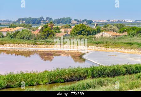 Siedlung rund um eine rosa Salz Verdunstung Teich in der Camargue in Südfrankreich Stockfoto