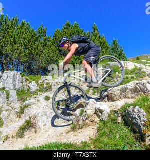 Weibliche Mountainbiker auf tricky Downhill im hochalpinen und felsiges Gelände Stockfoto