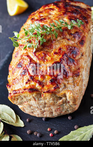 Köstliche ganze Hähnchen Hackbraten auf einer Schiefertafel Fach mit Zitronenscheiben und frischem Thymian auf einen konkreten Tisch serviert, vertikale Ansicht von oben Stockfoto