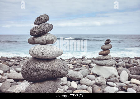 Pyramiden aus Steinen am Strand, Farbe getonte Bild. Stockfoto